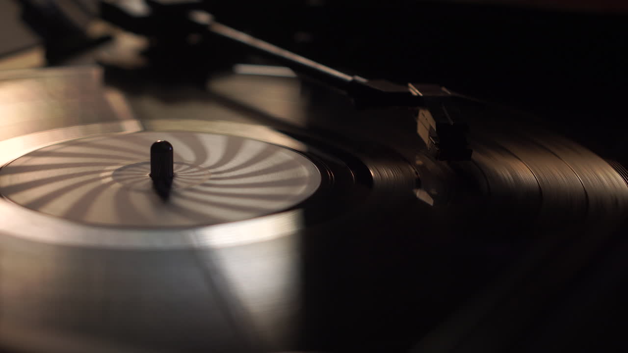 Disco in vinile che gira e puntina di un giradischi vintage, primo piano.