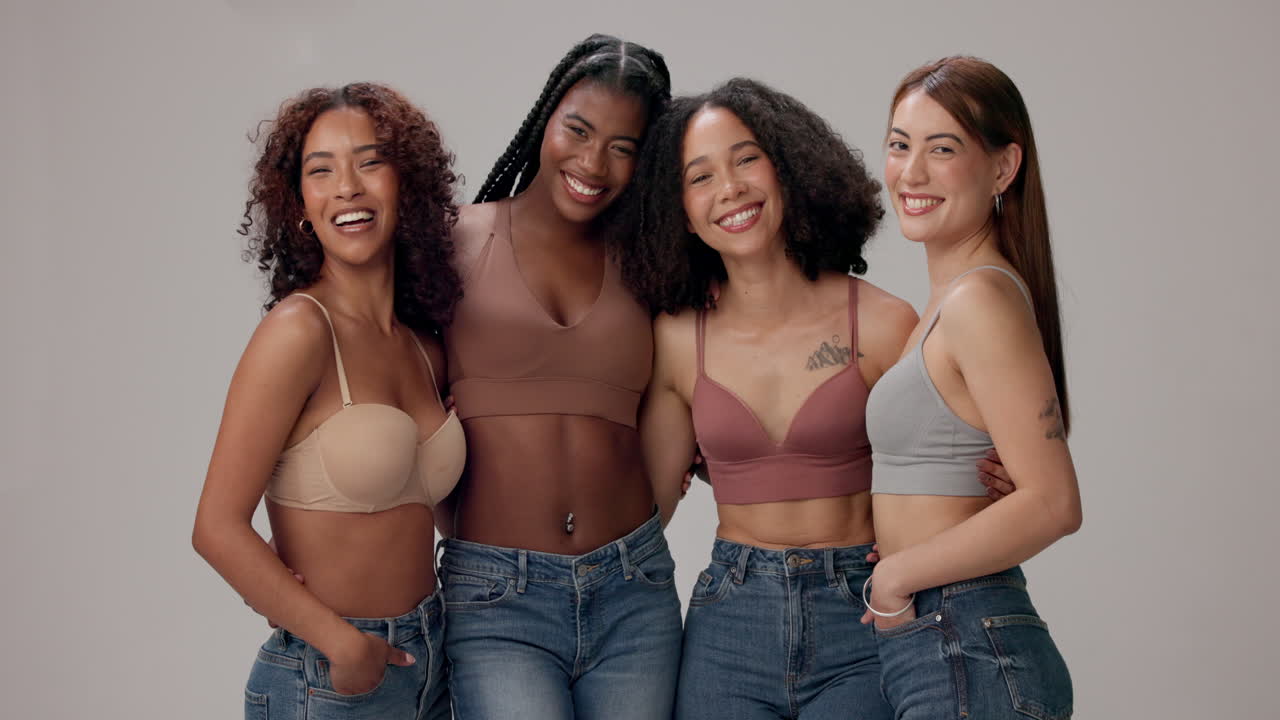quatro mulheres jovens sorrindo e posando juntas em um estúdio