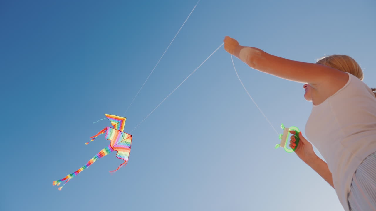 descanso activo en la playa - mujer jugando con la vista inferior de la cometa