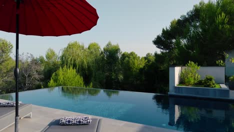 slow dolly past sunlounger at a private pool in the garden of a villa in st gely du fresc