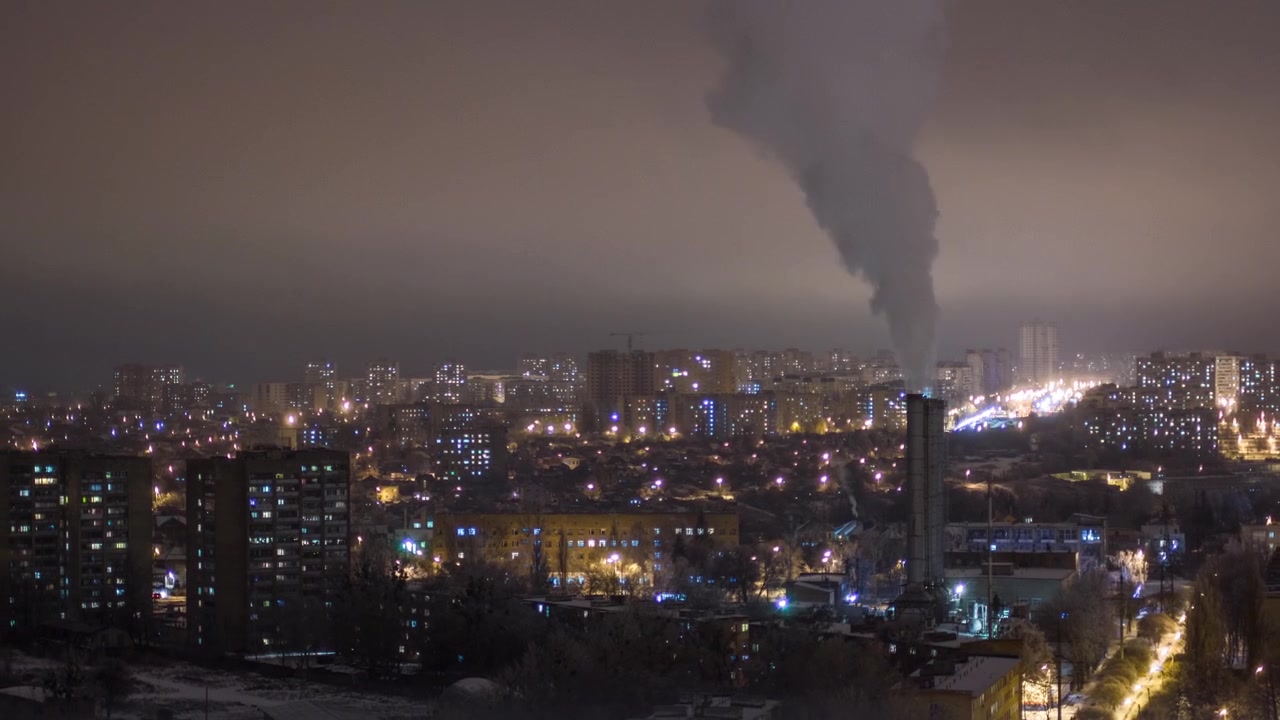 Ciudad de Járkov desde arriba timelapse nocturno en invierno. Vista aérea del centro de la ciudad y distritos residenciales con chimeneas humeantes. Ucrania