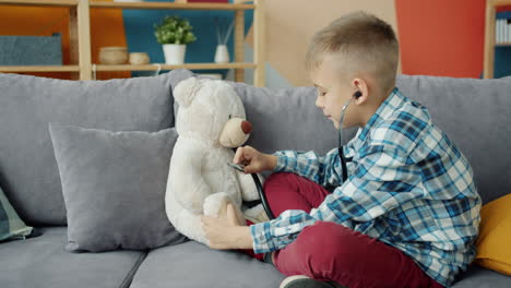 boy playing doctor with teddy bear