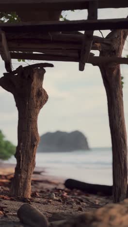 small beach hut with a panoramic view of ocean waves and a rocky island in the distance under a clear sky