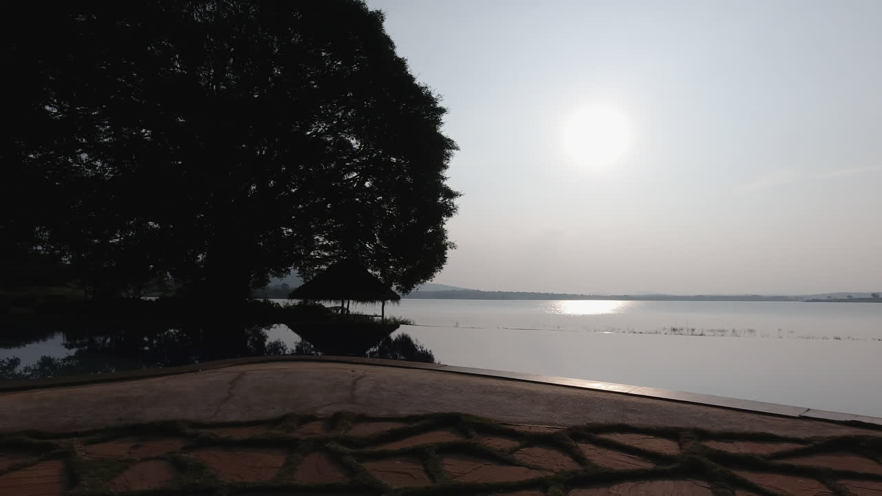 A serene view of a resort by the Kabini River, showcasing an infinity pool and tranquil surroundings