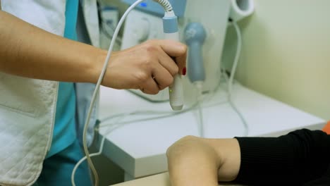 el fisioterapeuta trata al paciente con rsi en la muñeca con láser