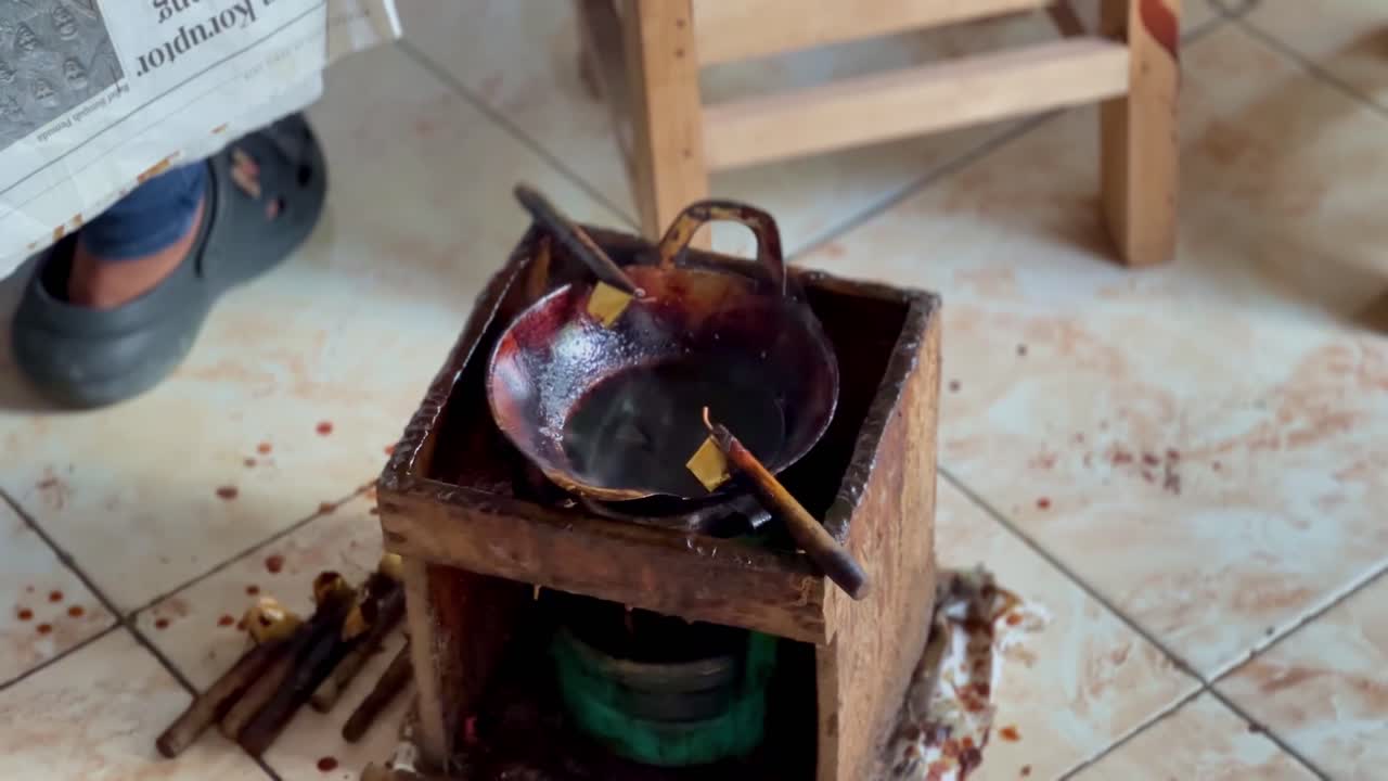 The "canting" tool is in a small pan filled with hot liquid wax