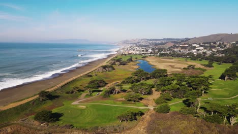 aerial view of mori point beach coastal cliffs with turquoise waves hitting the shore, drone pan right shot