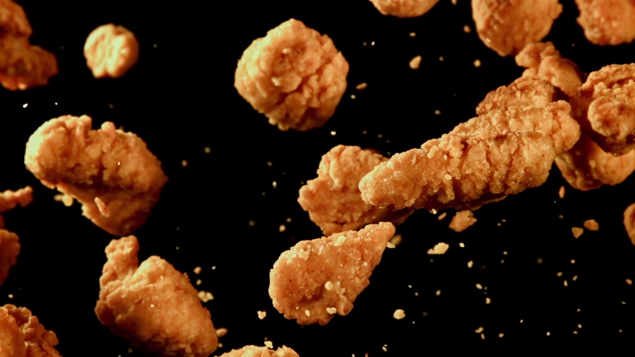 Nugget dan Strip Ayam Goreng Renyah Mengambang dalam Gerak Lambat
