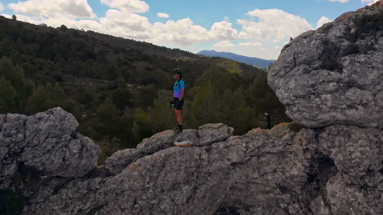 ciclista bebe en la cima de una montaña