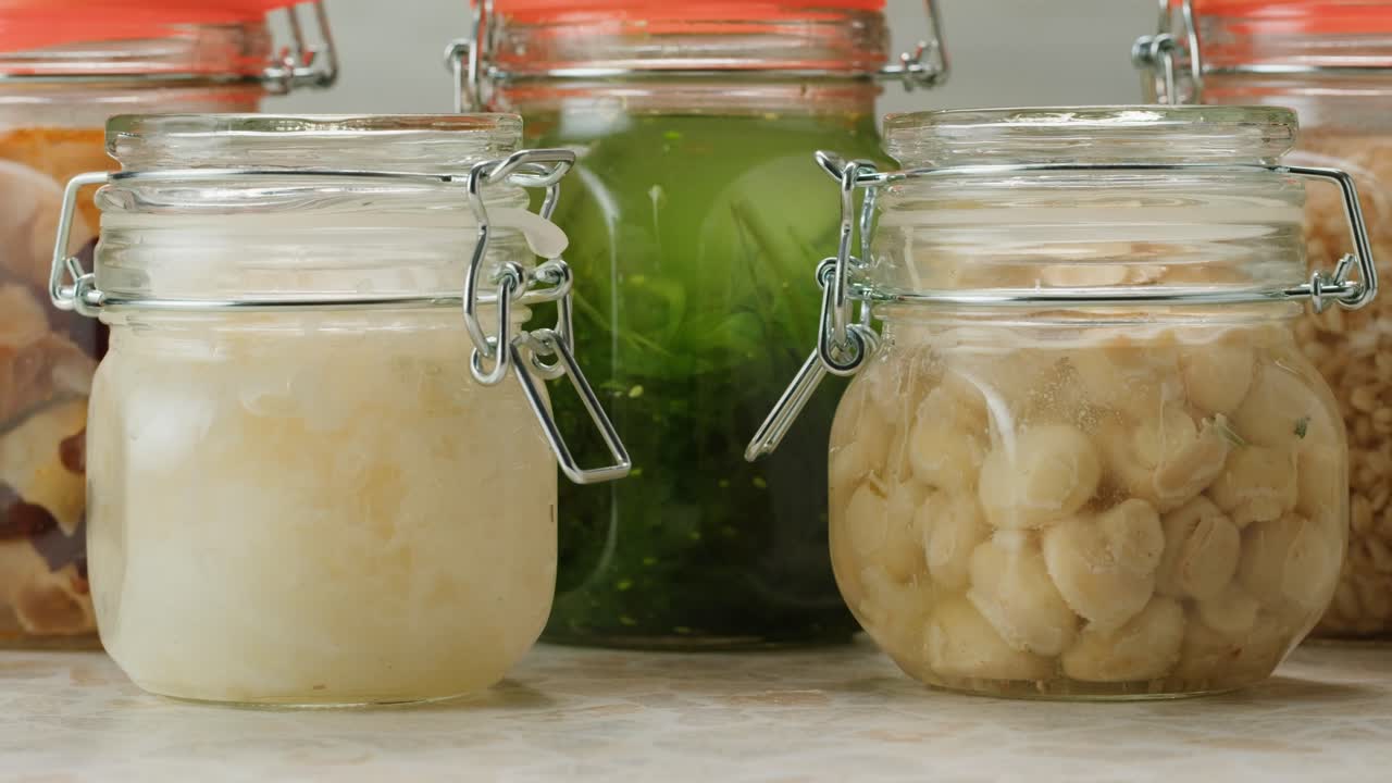 Fermented champignons, Jar with marinated mushrooms on wooden table, traditional salted marinated asian food.