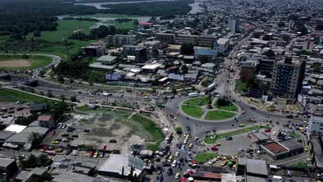 Aerial view of Rond-Point Deido roundabout, towards a industrial area in Douala city, Cameroon - pan, drone shot