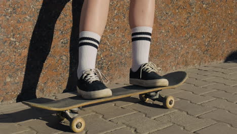 die füße eines nicht erkennbaren skatermädchens auf einem skateboard 1