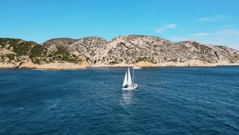 Das-Segelboot-Segelt-über-Das-Offene-Meer,-Während-Sich-Die-Drohne-Zurückzieht-Und-Eine-Atemberaubende-Landschaft-Freigibt