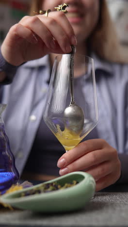 woman preparing a floral tea drink