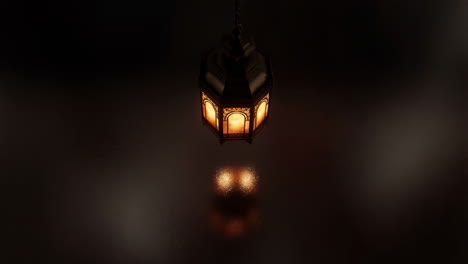 an ornate hanging lantern glowing warmly in the dark with reflections below