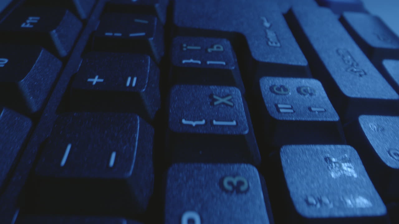 어두운 파란색 백라이트 키보드의 클로즈업 뷰