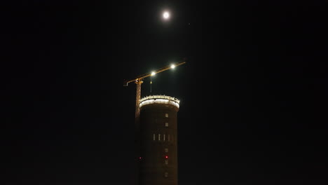low angle drone shot orbiting the prysmian tower construction, night in finland