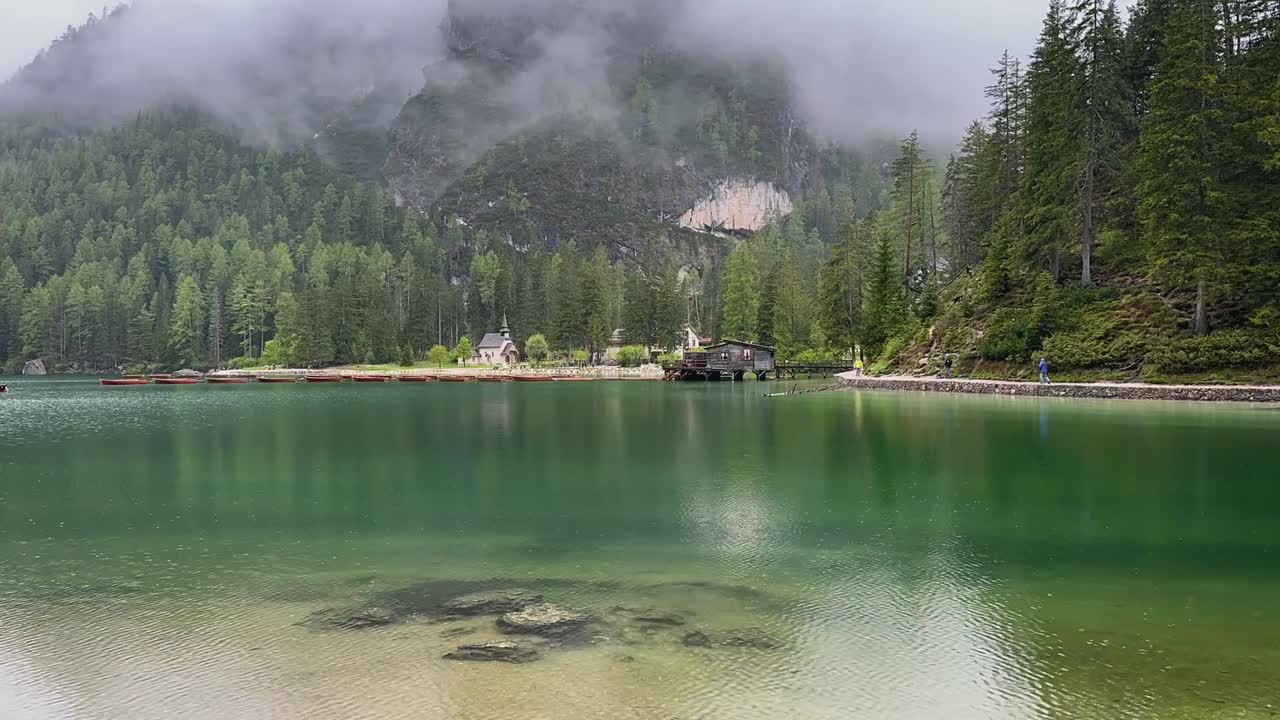 Rainy timelapse at Lago di Braies, showcasing moving clouds, pine forests, and a tranquil lake, suitable for travel vlogs or scenic outdoor content