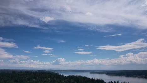 Hohe-Zirruswolken-Ziehen-Langsam-über-Einen-Strahlend-Blauen-Himmel-Und-Werden-Von-Ruhigen-Gewässern-Reflektiert,-Ein-Hyperlapse-Aus-Der-Luft