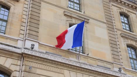 Malerische-Aussicht-Auf-Die-Wehende-Französische-Flagge-An-Der-Stange-An-Einem-Pariser-Gebäude-In-Paris,-Frankreich