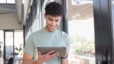 smiling man using tablet in modern interior design office, enjoying technology