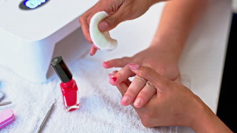 las manos de la mujer en el spa, removedor de esmalte de uñas