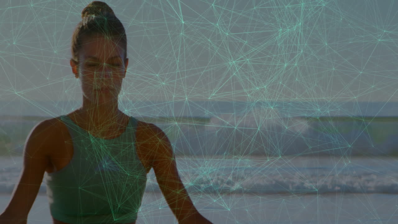 Meditating woman on beach with digital network animation in background