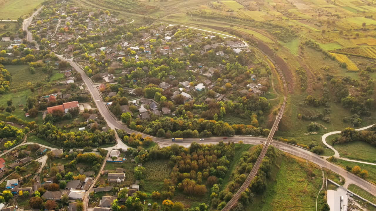 Aerial drone view of village in Moldova. Residential buildings, greenery, road with moving cars