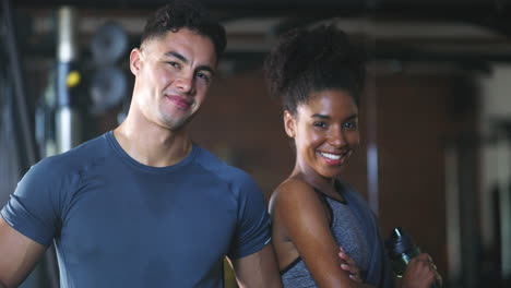 two fit young people standing together in the gym