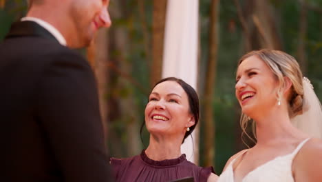 smiling bride and celebrant laughing at outdoor wedding ceremony alter, 4k resolution slow motion