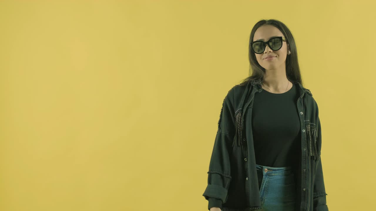 joven hermosa con bolsas de compras en el fondo amarillo