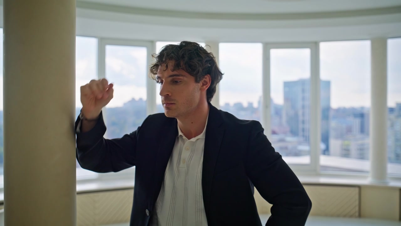 Worried businessman pacing luxury apartment. Man rubbing temple stressed.