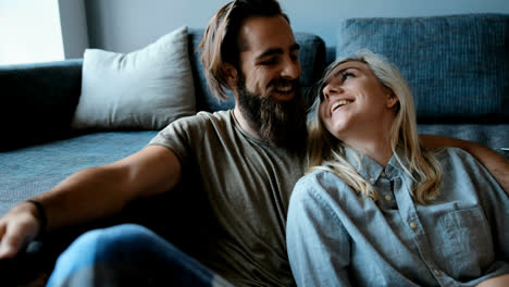 couple watching television in living room 4k