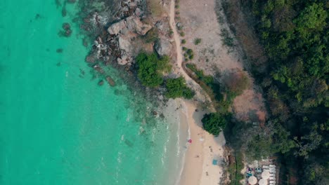 Las-Olas-Del-Océano-Azul-Ruedan-Sobre-La-Playa-De-Arena-Y-La-Costa-Rocosa.