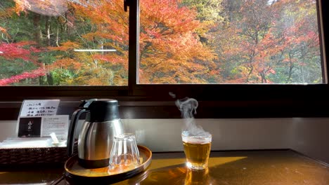 calm scenery with hot tea inside japanese restaurant with autumn colors