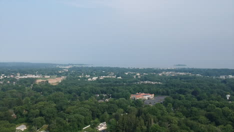 slow descent of a drone over a suburban neighborhood with buildings in the distance