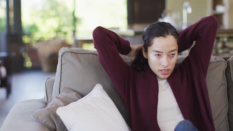 Biracial-woman-relaxing-on-sofa