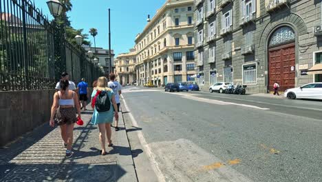 people walking along a sunny street in naples