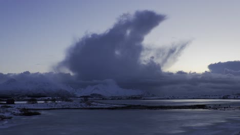 panoramic view of giant clouds over snow-covered mountains in a cold winter day