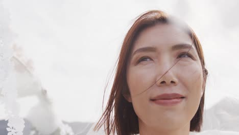 video of happy asian bride smiling under white decorations at outdoor wedding