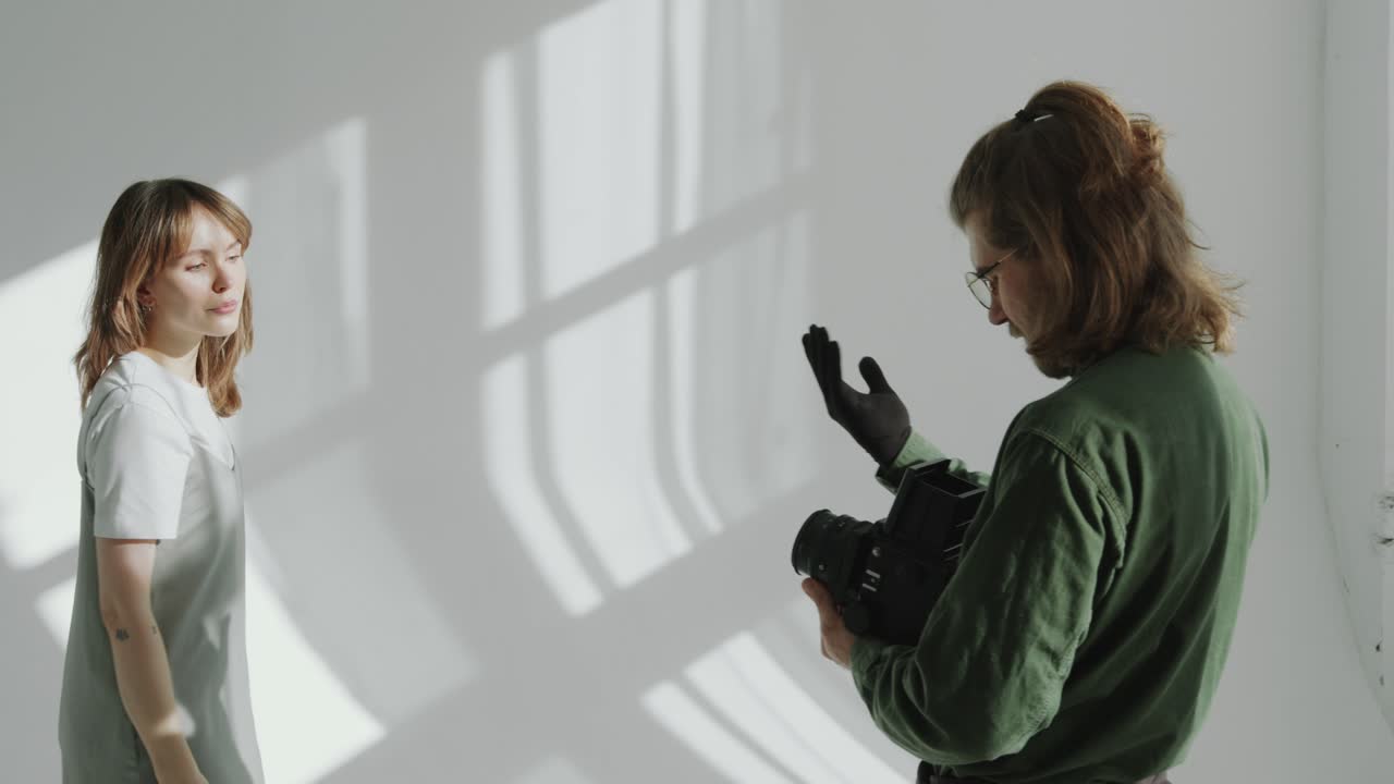 Photographer Taking Pictures of Model on White Cyclorama Wall in Studio