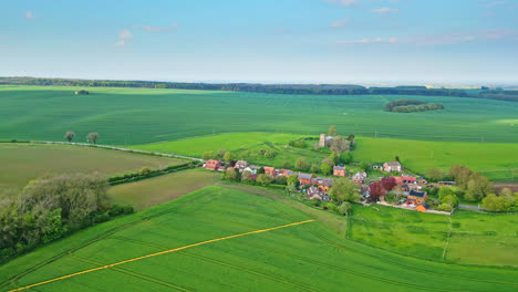 aerial drone perspective exhibits burwell village, once medieval market town—country fields, aged red brick homes, and the idle saint michael parish church on lincolnshire's wold hills