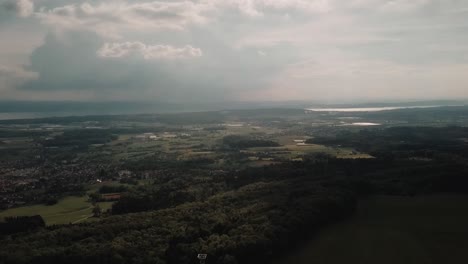 un dron se desplaza lentamente sobre los bosques que rodean el lago constance.