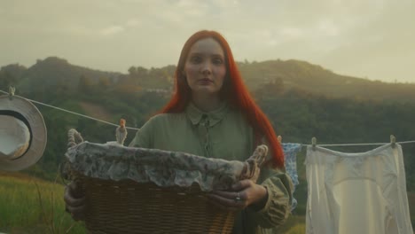 woman with laundry basket in the countryside at sunset