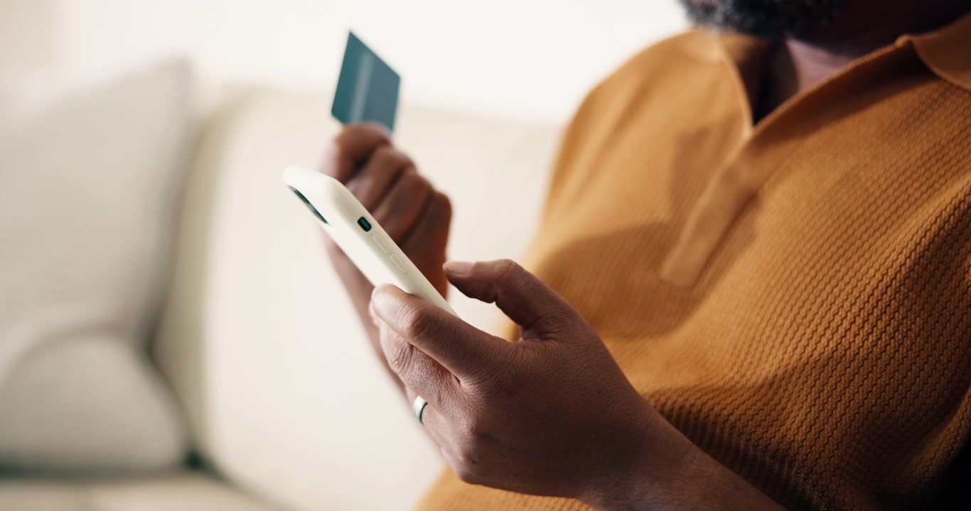 Man Holding Credit Card and Using Smartphone for Online Shopping