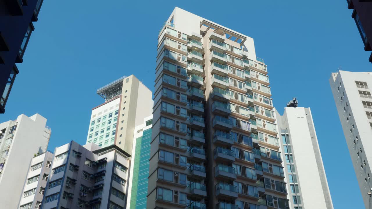 Vista panorámica de edificios de apartamentos y rascacielos en el centro de Hong Kong, China, en un día soleado, mostrando la densa vida urbana y la arquitectura moderna.