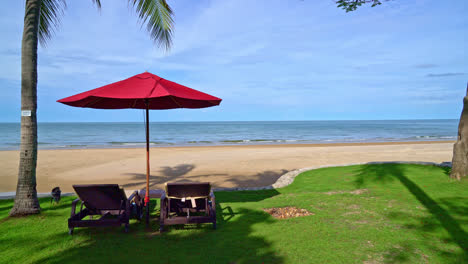 Sombrilla-Roja-Y-Silla-De-Playa-Con-Fondo-De-Playa-Y-Cielo-Azul-Y-Luz-Solar