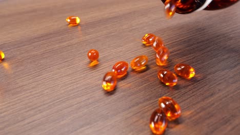 Gießen-Sie-Orangefarbene-Kapseln-Omega-3-Pillen-Als-Symbol-Einer-Überdosis,-Fallen-Aus-Dem-Glas