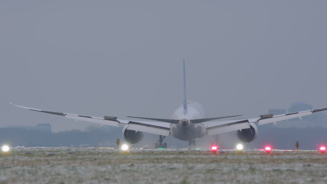 Grande aereo passeggeri in atterraggio su pista innevata con tempo coperto
