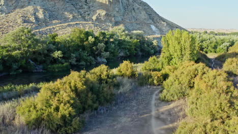 Aerial-around-Spanish-countryside-with-nature-riverbed,-reflective-water,-day